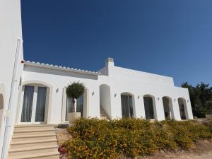 a white house with stairs and flowers at Boutique Guesthouse-Moncarapacho in Moncarapacho