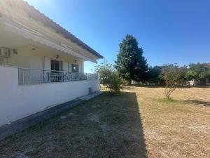 a house with a balcony and a yard at MELIA Holidays & Living in Epanomi