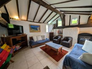 a living room with a couch and a tv at Maison d'hôtes de charme ttakoinenborda in Sare