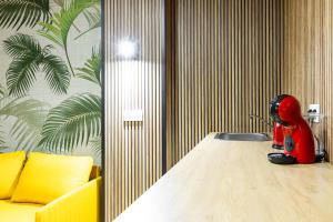 a red robot sitting on a table next to a yellow couch at YES! Rooms in Alicante