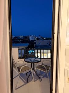 a table and chairs on a balcony with a view at Skala Apartments in Agia Marina Nea Kydonias +3 photos