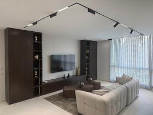 a living room with a couch and a tv at Nitza 14 in Netanya