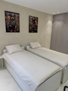 two beds sitting next to each other in a room at Nitza 14 in Netanya +3 photos