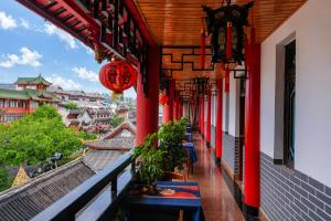 a balcony of a building with red columns and blue tables at Wenjun Courtyard Hotel Chengdu ,English-Speaking , Pick-up Service ,Laundry Service , Local Tours in Chengdu
