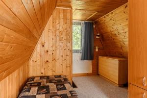 a room with a bed in a wooden cabin at Chatka Jitka kytka in Jedovnice