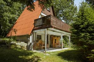 a house with an orange roof with a porch at Chatka Jitka kytka in Jedovnice