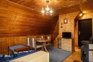 a dining room with a table and a television in a cabin at Chatka Jitka kytka in Jedovnice
