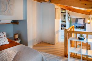 a bedroom with a bed and a staircase in a room at le duplex de l'Hôtel de ville in Lourdes