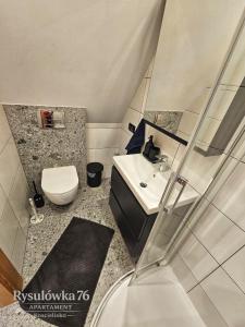 a small bathroom with a toilet and a sink at Apartament Rysulówka 76 in Kościelisko