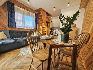 a living room with a table and chairs and a couch at Apartament Rysulówka 76 in Kościelisko