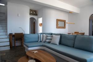 a blue couch in a living room with a table at Villa Anemelia Tinos in Agios Ioannis
