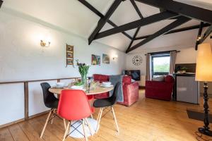 a living room with a table and chairs at Braddon - Treworgie Barton Cottages in Bude