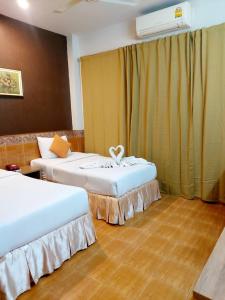a hotel room with two beds and a radiator at Suriwong Chumphon Hotel in Chumphon