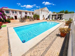 a swimming pool in front of a house at Cortijo Domínguez - Rural Experience in Lucena