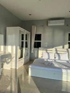 a bedroom with a white bed and a desk at The Sunset Suite Panoramic Sea Views in Sikao