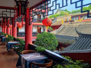 a building with tables and chairs in front at Wenjun Courtyard Hotel Chengdu ,English-Speaking , Pick-up Service ,Laundry Service , Local Tours in Chengdu