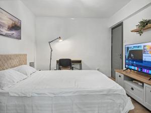 a bedroom with a white bed and a television at Konstanzer 3 - Spacious 2-Room Apt - Iulius Mall in Iaşi