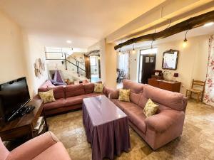 a living room with a couch and a tv at Cortijo Domínguez - Rural Experience in Lucena