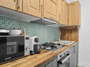 a kitchen with a stove and a microwave at Konstanzer 3 - Spacious 2-Room Apt - Iulius Mall in Iaşi