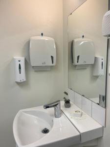 a white bathroom with a sink and a mirror at Ängsstugan in Orkelljunga +11 photos