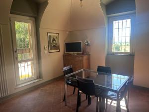 a dining room with a table and chairs and a tv at Casia Vacanze con due appartamenti in Bene Vagienna