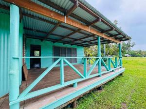 ein blaues Haus mit einer großen Holzterrasse in der Unterkunft Niusiladi in Taveuni