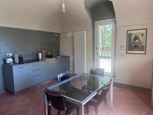 a kitchen with a glass table and some chairs at Casia Vacanze con due appartamenti in Bene Vagienna