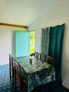ein Esstisch mit grüner Tischdecke und Stühlen in der Unterkunft Niusiladi in Taveuni + 7 Fotos