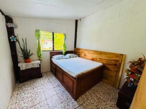 ein kleines Schlafzimmer mit einem Bett und einem Fenster in der Unterkunft Niusiladi in Taveuni