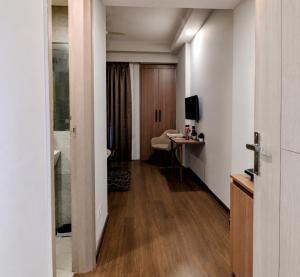 a room with a hallway with a desk and a television at TOM n JERY STAYS in Greater Noida