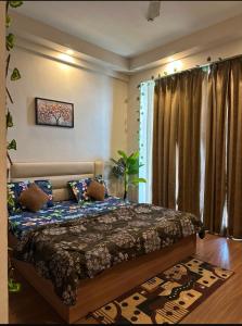 a bedroom with a bed and a large window at TOM n JERY STAYS in Greater Noida
