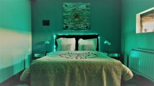 1 dormitorio con 1 cama grande y pared verde en La Magie des Rêves, en Montréjeau