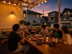 a group of people sitting around a table with food at Daiwa House BBQ 琵琶湖徒步3分 無料駐車4台プロジェクター in Takashima