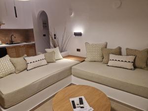 a living room with two couches and a table at Filoxenia Studios in Kithnos