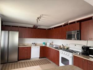 a kitchen with wooden cabinets and white appliances at Casa Larisa Borsa in Borsa