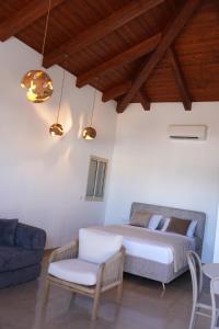 a bedroom with a bed and a couch and a chair at Pinat HaNahal in HaGoshrim