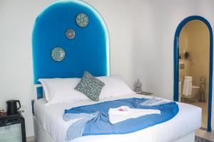 a bed with a blue headboard with a shirt on it at Dar Beate Sousse Medina in Sousse