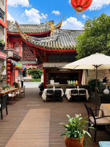 a restaurant with tables and chairs in front of a building at Wenjun Courtyard Hotel Chengdu ,English-Speaking , Pick-up Service ,Laundry Service , Local Tours in Chengdu