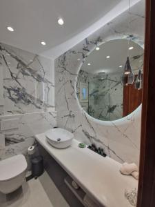 a bathroom with a sink and a toilet and a mirror at Filoxenia Studios in Kithnos