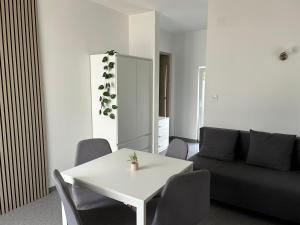 a living room with a white table and a couch at Mozaik Apartman in Kalocsa