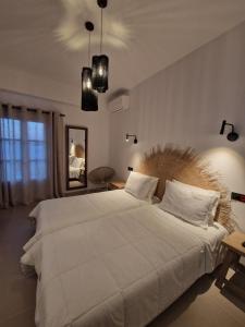 a large white bed in a room with a mirror at Filoxenia Studios in Kithnos
