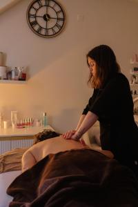 a woman sitting on a bed in a room at Ons Hofke in Lubbeek