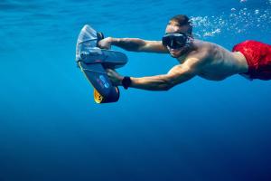 a man swimming in the water with a skateboard at bahati blue riviera in Mandelieu-La Napoule