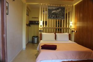 a bedroom with a large bed with white pillows at Welcome Inn in Ella