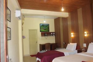 a hotel room with two beds and a desk at Welcome Inn in Ella