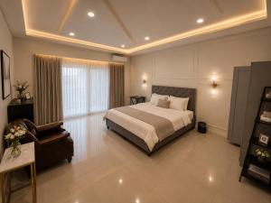 a large bedroom with a bed and a chair at 52stone scent poolvilla - A in Angeles +6 photos