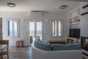 a living room with a couch and a tv at Villa Anemelia Tinos in Agios Ioannis