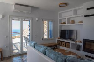 a living room with a couch and a television at Villa Anemelia Tinos in Agios Ioannis +41 photos