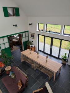 a large living room with a wooden table and windows at Lon Godrum in Kingsburgh