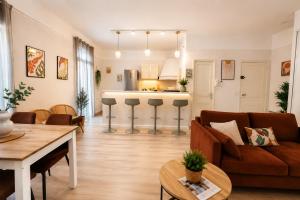 a living room with a couch and a kitchen at Gare - Spacieux T2 avec Clim Balcon Wifi in Perpignan